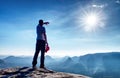 Man on edge of cliff high above misty valley. Travel hiking and Lifestyle. Royalty Free Stock Photo