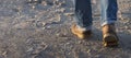 Man walking forward on sand, moving feet with leather boots and rolled up jeans, leisure activity or working concept, selected