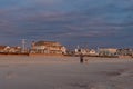 A man walking his dog along the beach at sunrise Royalty Free Stock Photo