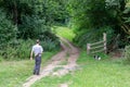 Man walking his dog in the countryside on a Sunday afternoon in summer