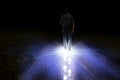 Man walking with light foot prints in darkness Royalty Free Stock Photo