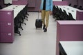 Man walking in office while wheeling his trolley bag Royalty Free Stock Photo