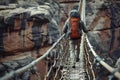 a man walking over a suspension bridge above a canyon on a hiking trip Royalty Free Stock Photo