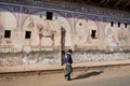 Man walking past painted walls in the ancient Indian style