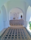 Man walking on pebbles floor with shapes.