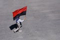 Man walking with red and black flag in hand Royalty Free Stock Photo