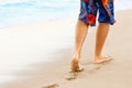 Man walking on sand beach leaving footprints in the sand. ÃÂ¡lose up of man leg on the beach. Royalty Free Stock Photo