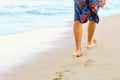 Man walking on sand beach leaving footprints in the sand. ÃÂ¡lose up of man leg on the beach. Royalty Free Stock Photo