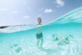 Man walking on sand seabed of turquoise sea