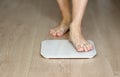 Man walking on scales measure weight. male wal checking BMI weight loss. human barefoot measuring body fat overweight Royalty Free Stock Photo