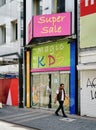 Male figure waling past a kids store that has been shut down in Cologne, Germany