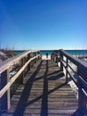 Man Walking Small Dog on a Florida Beach from Boardwalk. Royalty Free Stock Photo