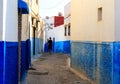 Man walking in the small streets in blue and white in the kasbah of the old city Rabat in Marocco