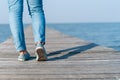 Man is walking on small wood bridge to nature walk way with sunlight flare Royalty Free Stock Photo