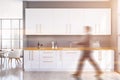 Man walking in spacious gray kitchen with table Royalty Free Stock Photo
