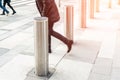 Man walking by stainless steel bollard entering pedestrian area on Vienna city street. Car and vehicle traffic access control Royalty Free Stock Photo