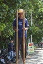 Man walking on stilts along roadside in Denpasar, Bali, Indonesia.