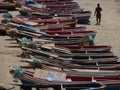 A man walking on Tarrafal beach beside many colorful small wooden boats Royalty Free Stock Photo