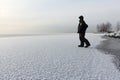 Man walking on a thin ice of a freezing pond at sunset Royalty Free Stock Photo