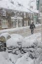 Man walking though heavy snowfall along Welsh High Street.