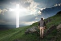 Man walking to the cross in a green field