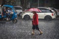 Man walking in tropical monsoon rain