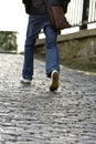 Man walking up a cobblestone road Royalty Free Stock Photo