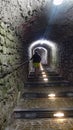 Man walking up the stairs in a dark tunnel of a medieval fort