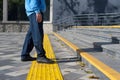 Man walking on yellow blocks of tactile paving for blind handicap.Braille blocks, tactile tiles for the visually impaired, Tenji