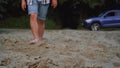 Man walks on the beach with bare feet