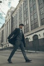 A man walks at city street in the image of an English retro gangster in Peaky blinders style