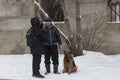 , the man walks with a German shepherd in the winter