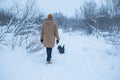 The man walks with his dog in a winter forest