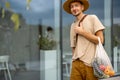 Man walks with a mesh bag full of fresh vegetables outdoors