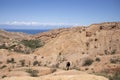 A man walks through Skazka Canyon in Kyrgyzstan with lake Issyk-Kul in the background