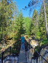 A man walks on a suspension bridge over the Akhvenkoski Waterfall on the Tokhmayoki River in Karelia on a sunny summer morning