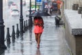 A man walks under an umbrella during the rain, having his face off the camera Royalty Free Stock Photo