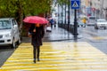 A man walks under an umbrella during the rain, having his face off the camera Royalty Free Stock Photo