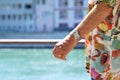 Elderly arm with expensive watch and flamboyant shirt on seafront