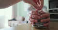 Man wants to take out several banknotes of cash from glass jar. Woman takes the piggy bank to herself. Family saving Royalty Free Stock Photo