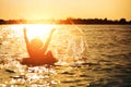 A man ware hat and he is on swim tube in the water. He is hands up to make water splash. Royalty Free Stock Photo