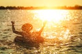 A man ware hat and he is on swim tube in the water. He is hands up to make water splash. Royalty Free Stock Photo