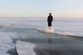 Man in warm clothes standing on the thin ice of a frozen river, Royalty Free Stock Photo