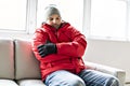 A Man With Warm Clothing Feeling The Cold Inside House on the sofa Royalty Free Stock Photo