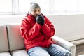 A Man With Warm Clothing Feeling The Cold Inside House on the sofa Royalty Free Stock Photo