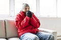 A Man With Warm Clothing Feeling The Cold Inside House on the sofa Royalty Free Stock Photo