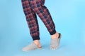 Man in warm soft slippers on light blue background, closeup Royalty Free Stock Photo