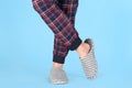 Man in warm soft slippers on light blue background, closeup Royalty Free Stock Photo