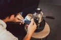 Man warming milk In metal jug with steam coffee machine at camping outdoor. Royalty Free Stock Photo