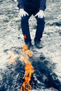 Man warms his hands over forever burning fire of mount Chimaera in Turkey